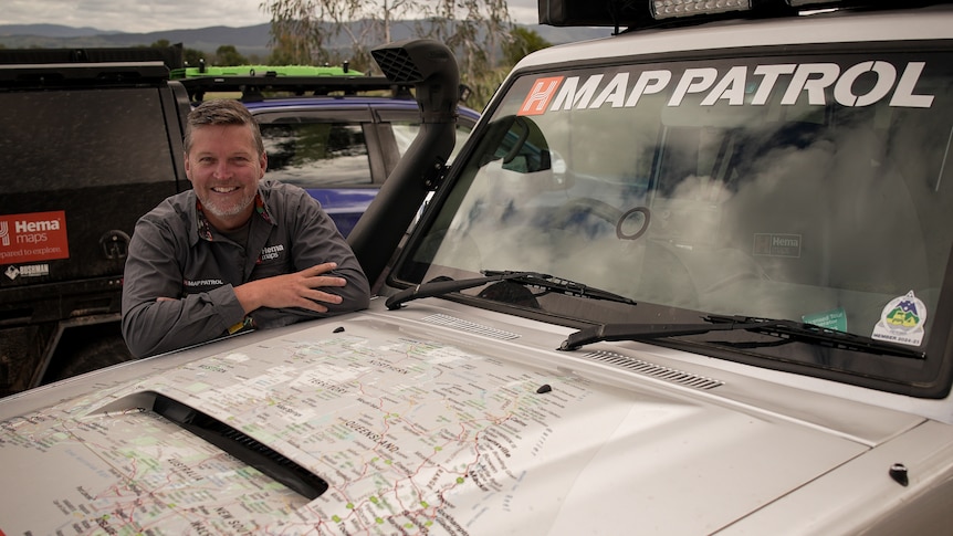 A man leans on the bonnet of a 4WD vehicle labelled MAP PATROL