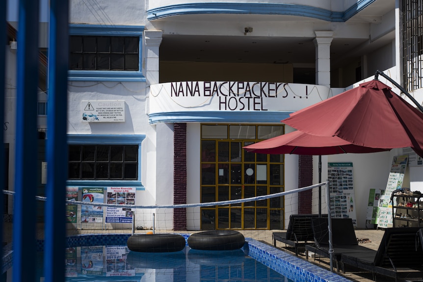 The outside of the Nana Backpackers hostel showing a pool and outdoor seating. 