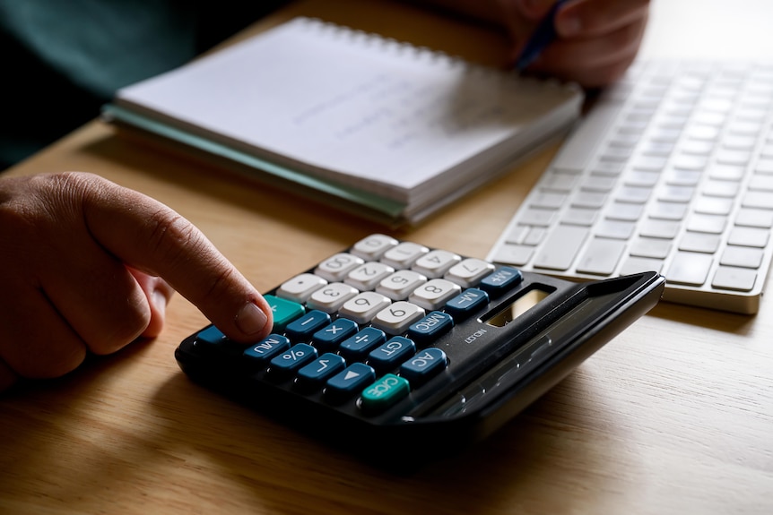 A stock photo of a person using a calculator