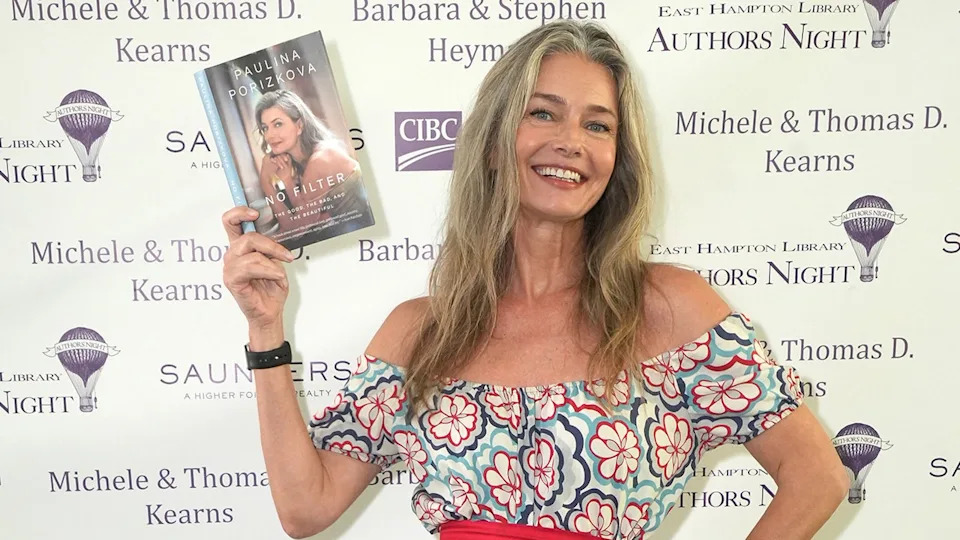 Paulina Porizkova holding her book
