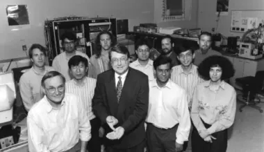A group of people standing in a lab surrounded by technical equipment.