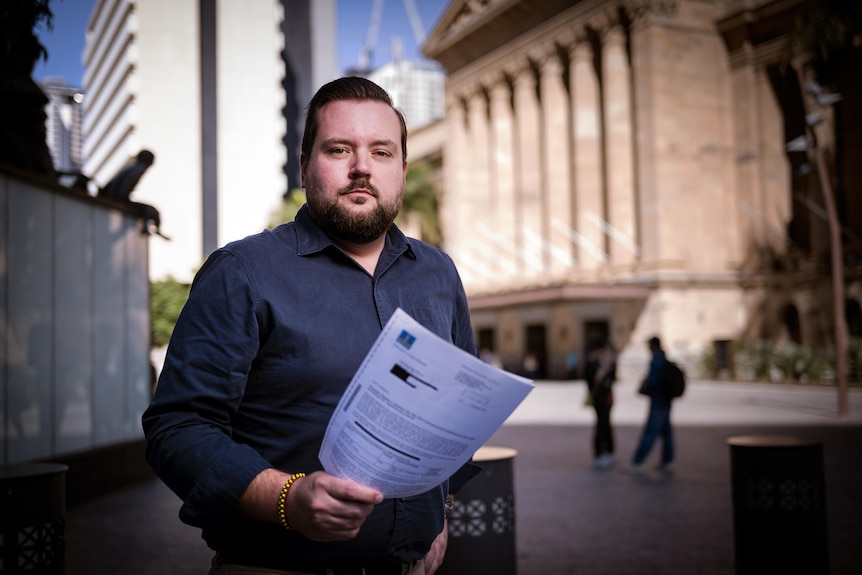 A stern man holding a letter