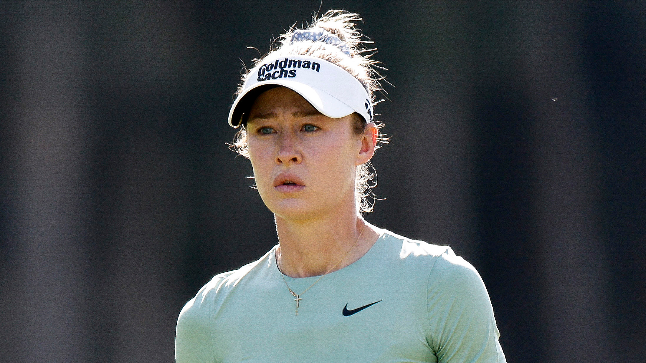 Nelly Korda wearing a white visor and green Nike top during an LPGA event