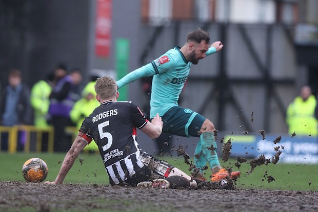 Adam Armstrong of Wolverhampton Wanderers and Harvey Rodgers of Grimsby Town battle for possession.