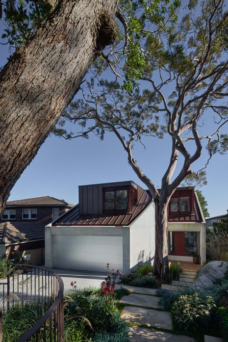 The house is set back from the street, preserving mature trees on the site.