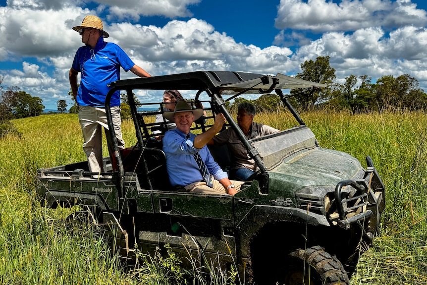 People on an ATV in long pasture.