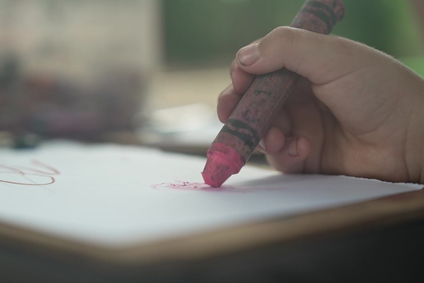 A child drawing with a crayon