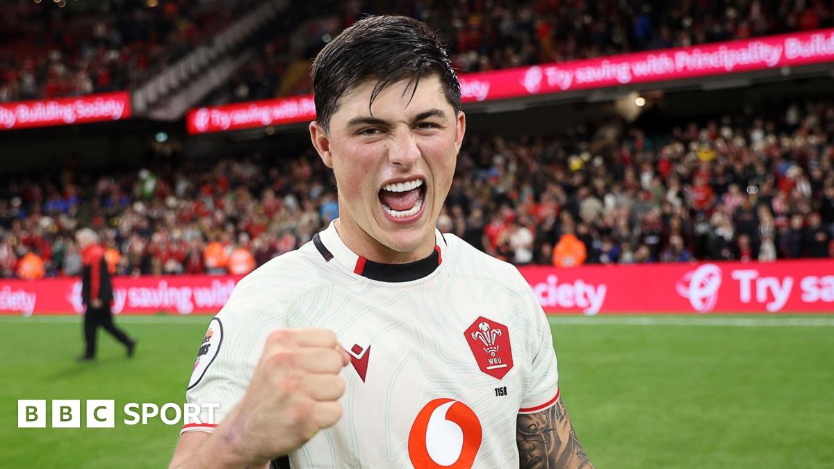 Louis Rees-Zammit pumps his fist in celebration for Wales while standing on the pitch