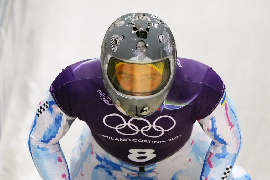 A winter athlete is wearing a helmet with black and white photos of people on it