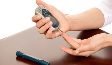 Unseen woman pricking their finger to test their blood sugar level to test for high blood sugar that can be a sign of prediabetes or type 2 diabetes