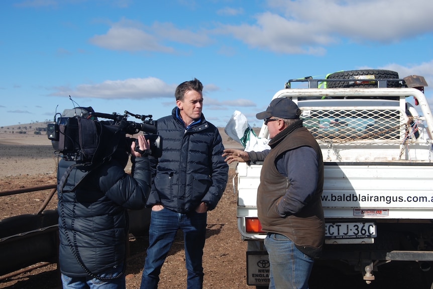 Michael Rowland interviews a farmer in a remote location in Australia
