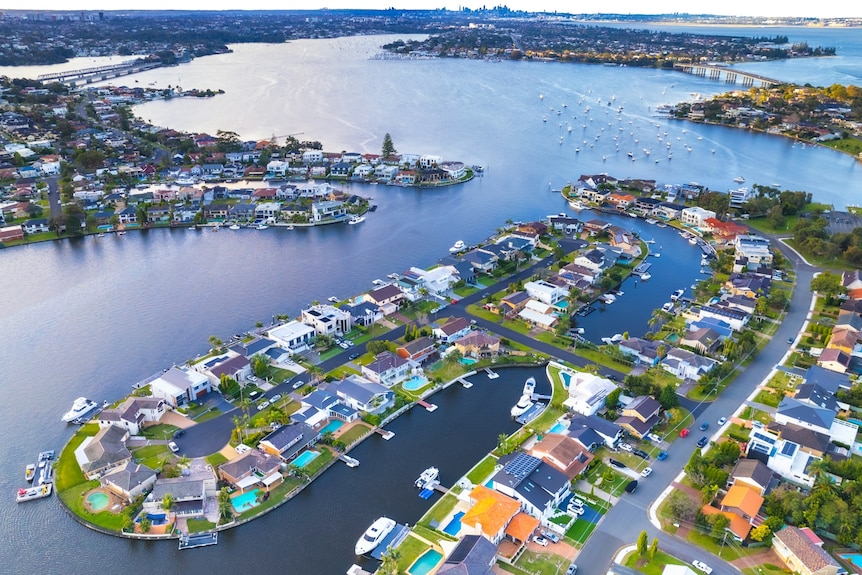 A drone shot of Sylvania Waters, a harbourside suburb with expensive homes, with Sydney Harbour stretching into the distance.