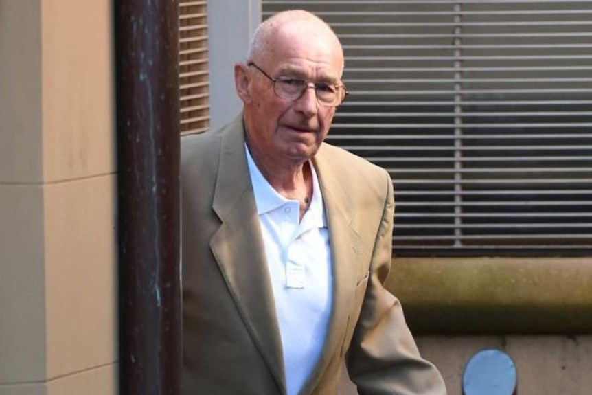 Roger Rogerson walking outside a building.