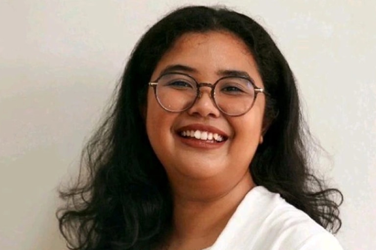 Woman in glasses with a long hair smiling to camera.
