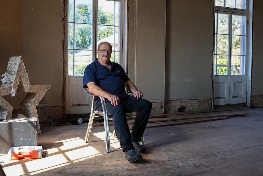 A man sitting in a rundown room.