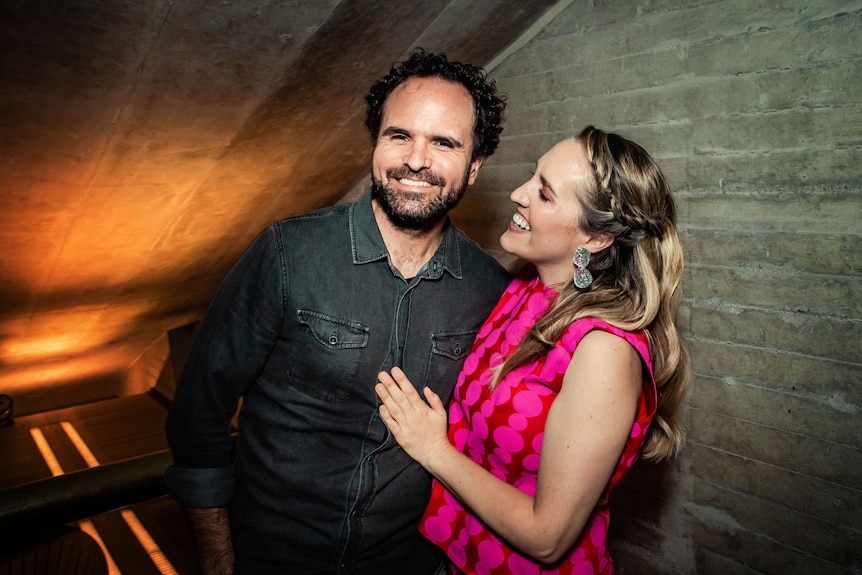 Tristan Coelho and Emily Granger pose together for a photo. Tristan smiles at the camera and Emily looks at Tristan smiling.