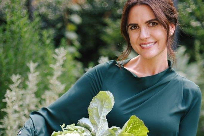 A woman holding fresh vegetables.