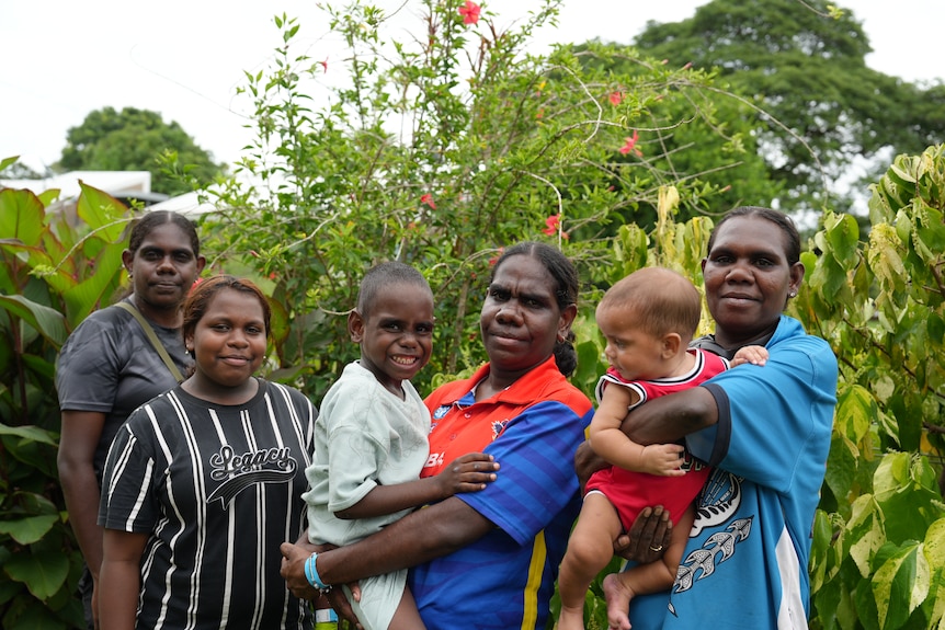 A group of women and two small children pose for the camera