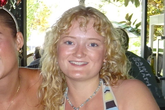 A young woman smiles to camera.