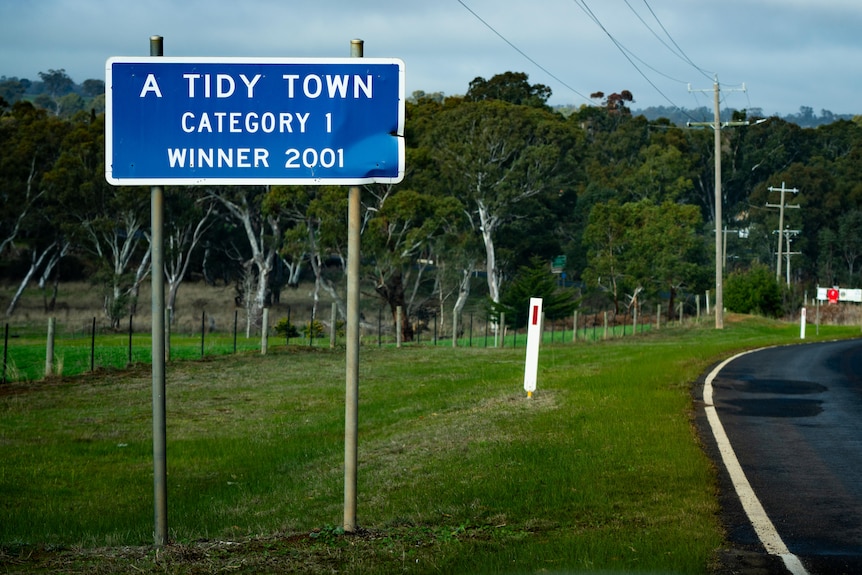 A sign by the road saying 'A Tidy Town Catergory 1 winner 2001'.