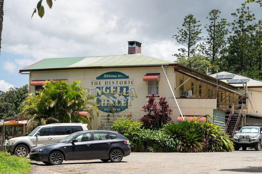 An old yellow building with a sign reading welcome to the historic Eungella chalet.