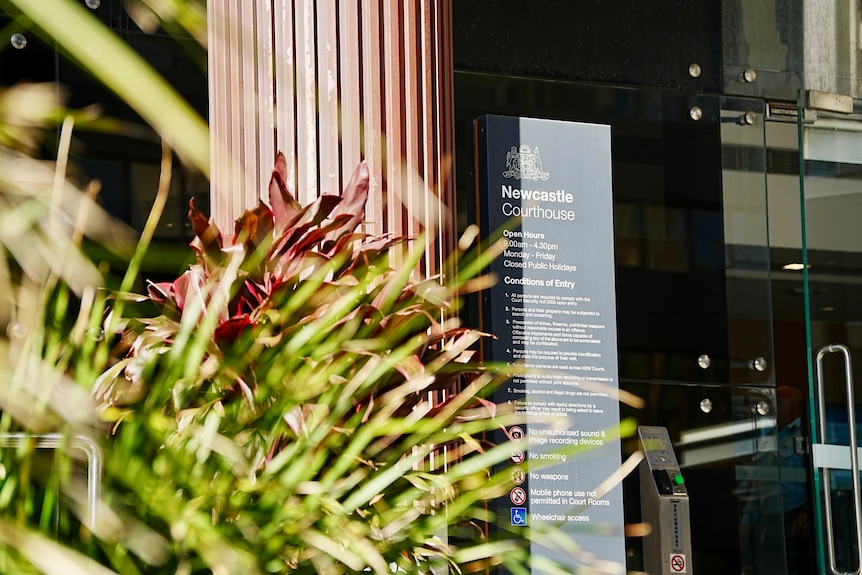 A sign that says "Newcastle District Court" outside a building