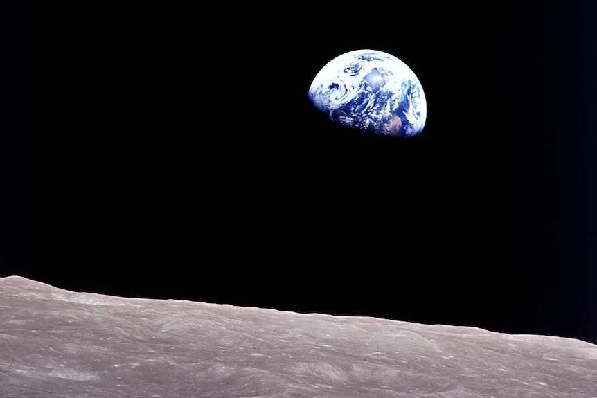 A small image of Earth against a black sky with the Moon landscape in the foreground.