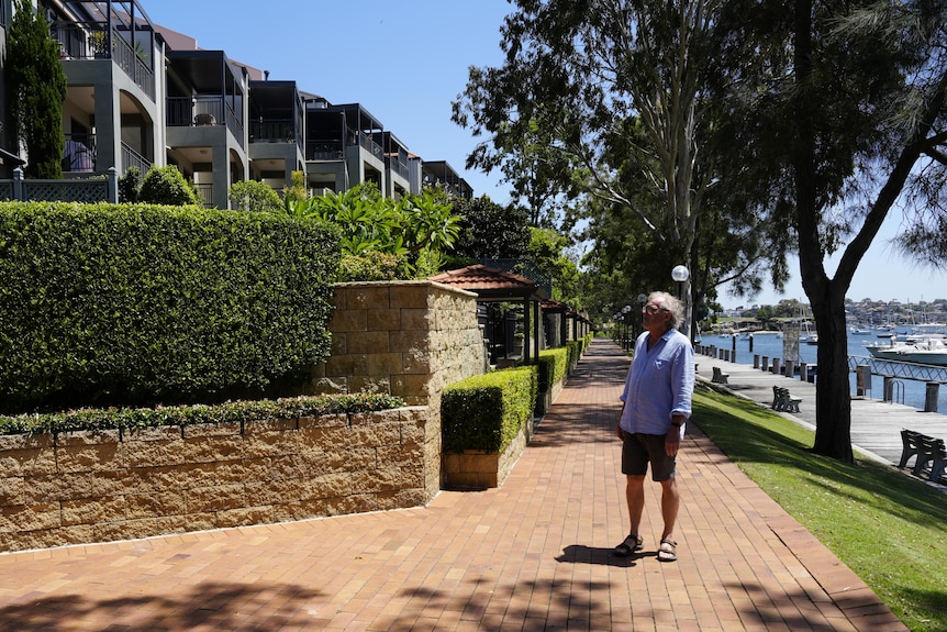 Duncan MacAuslan standing outside a residential complex near the water.
