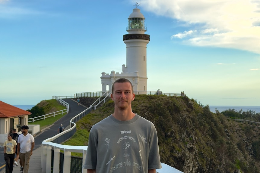 Brett Mckay poses for a photo in front of a lighthouse.