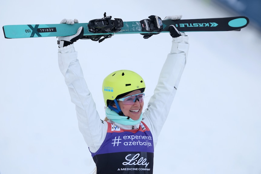 Danielle Scott holds up her skis after winning.