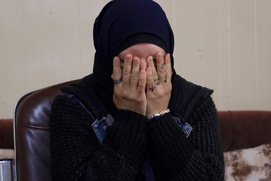 Kirsty Rosse-Emile covers her face with her hands as she sits in a chair for an interview.
