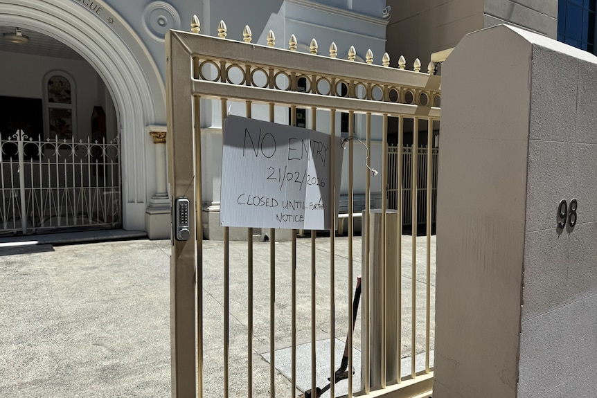 A sign reading 'no entry' on the gate of a synagogue