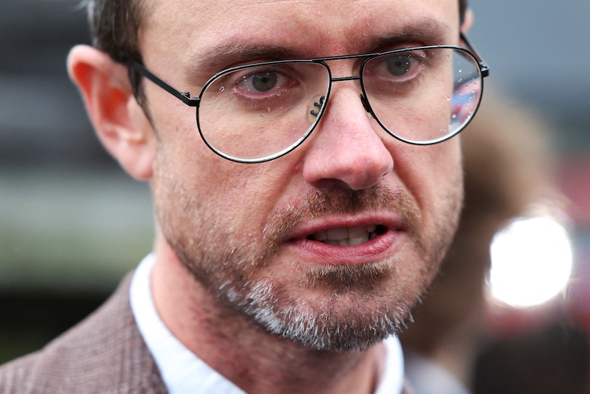 A close-up of Gabriel Shipton, who wears a serious expression.