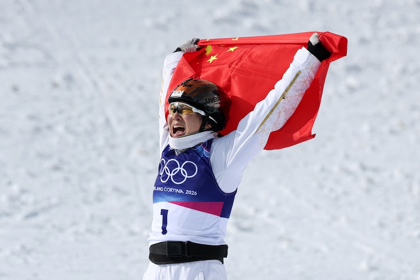 Xu Mengtao celebrates holding the Chinese flag above her head