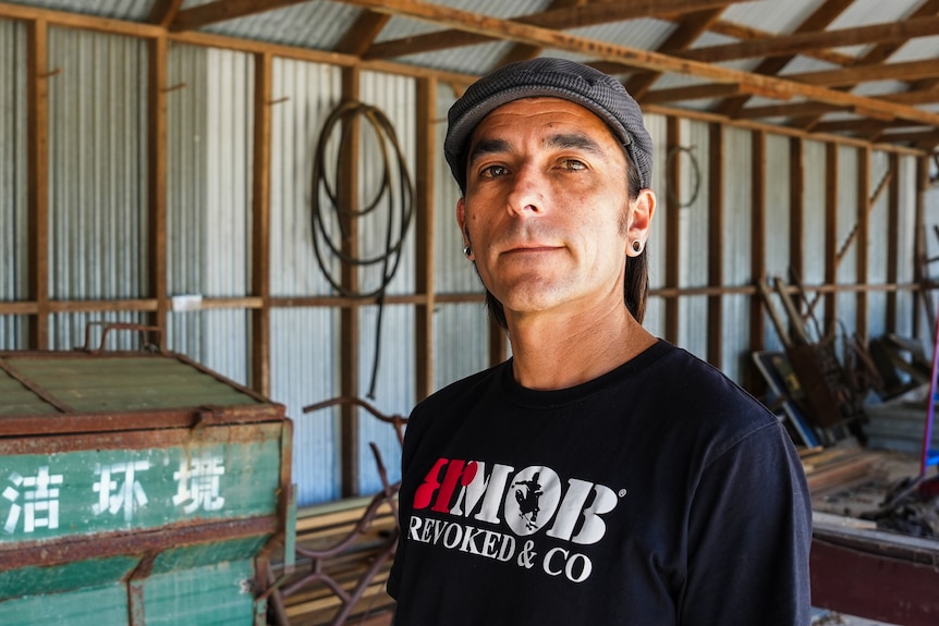 A man in a shed looking at the camera.