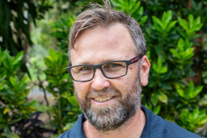 A man with a beard and glasses wearing a shirt that reads 'abbeystowe'