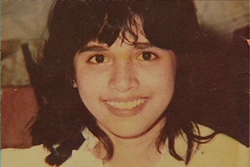 A sepia toned picture of a teenage girl smiling.