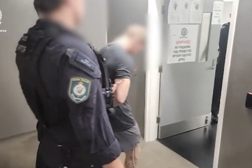 Police lead away a man in handcuffs