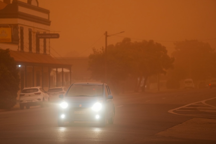 A car drives through a large dust storm in Broken Hill. 