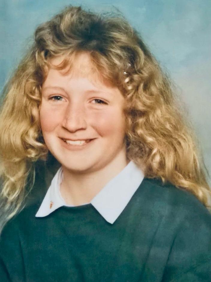 An old school photo of a girl, with wavy blonde hair.