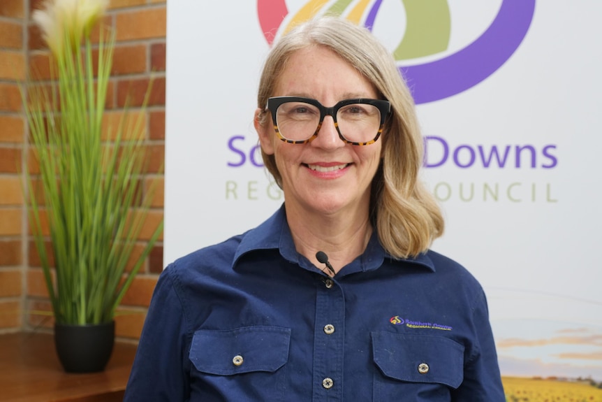 A woman standing on front of the Southern Downs Regional Council sign.