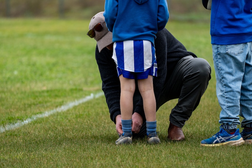 Under-14's coach Ed Ferguson ties one a boy's shoelaces.