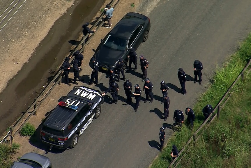 Aerial shot of NSW Police in dark uniforms walking in a line