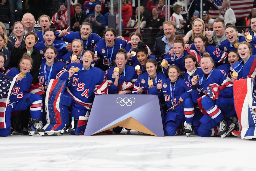 United States players celebrate with their gold medals after defeating Canada in the women's ice hockey