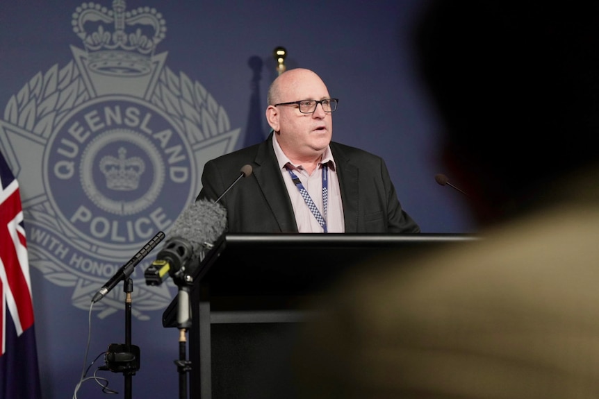 A police officer standing behind a lecturn speaking to media.