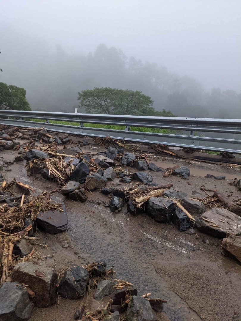 Rocks and mud cover a road.