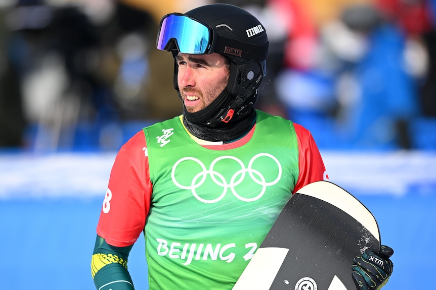 An Australian male snowboard cross athlete looks on at the Winter Olympics.