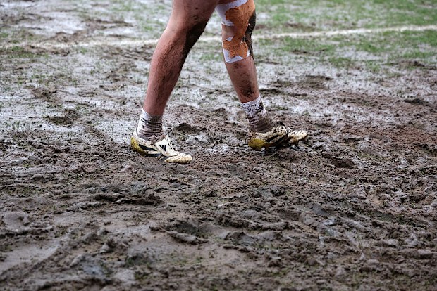 Jackson Smith of Grimsby Town warms up in thick mud.