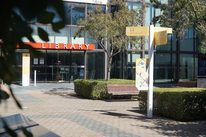 An sign showing where university buildings are located in front of a library