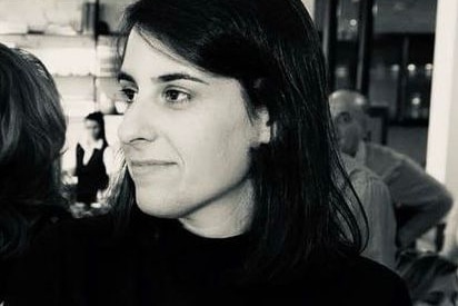 A black-and-white image of a dark-haired woman in a dark top.